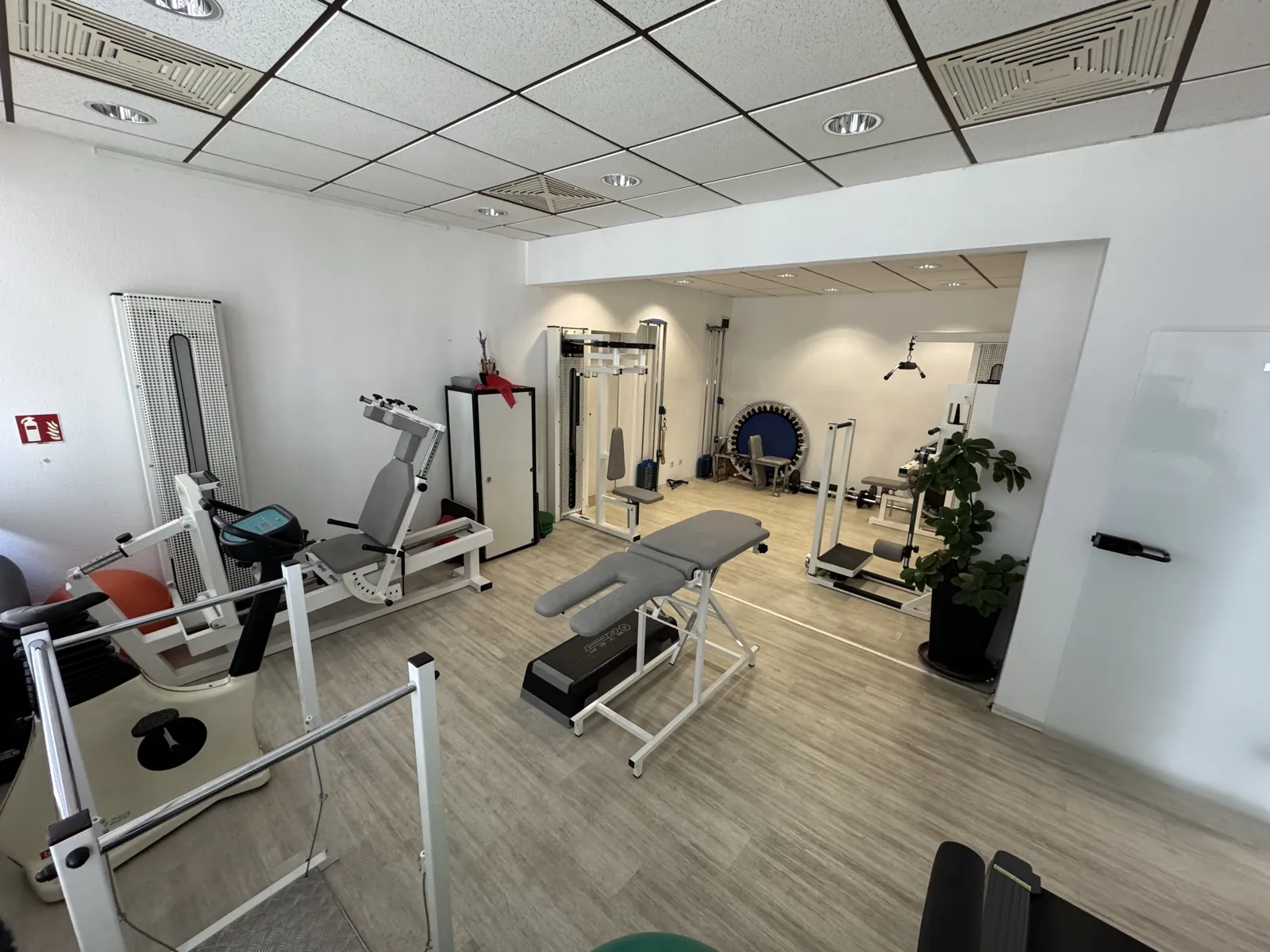 Trainingsraum der Praxis mit Kraftgeräten und Therapieliege